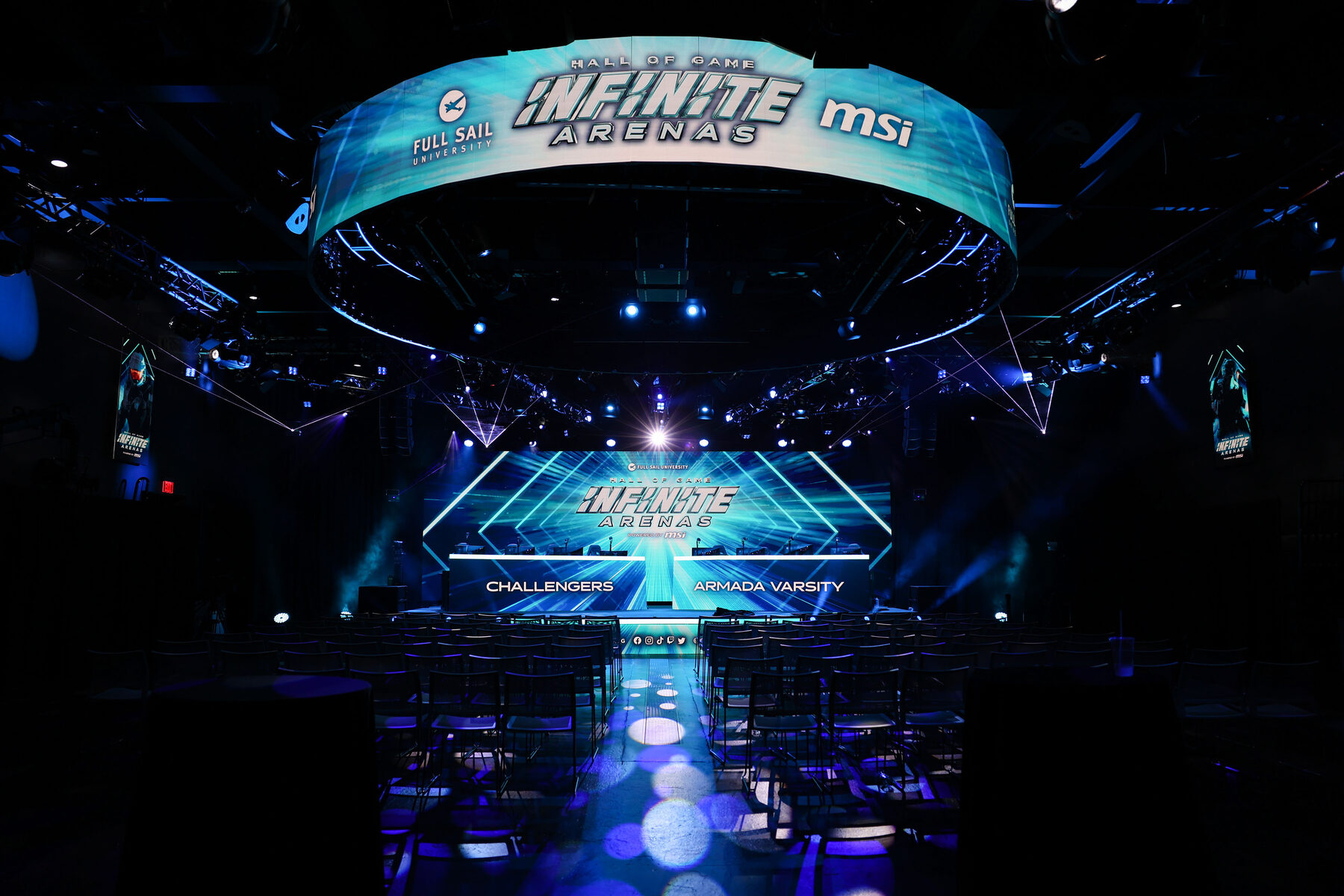 The arena from the floor: a circular LED ring carrying the Infinite Arenas and MSI logos hangs above the stage