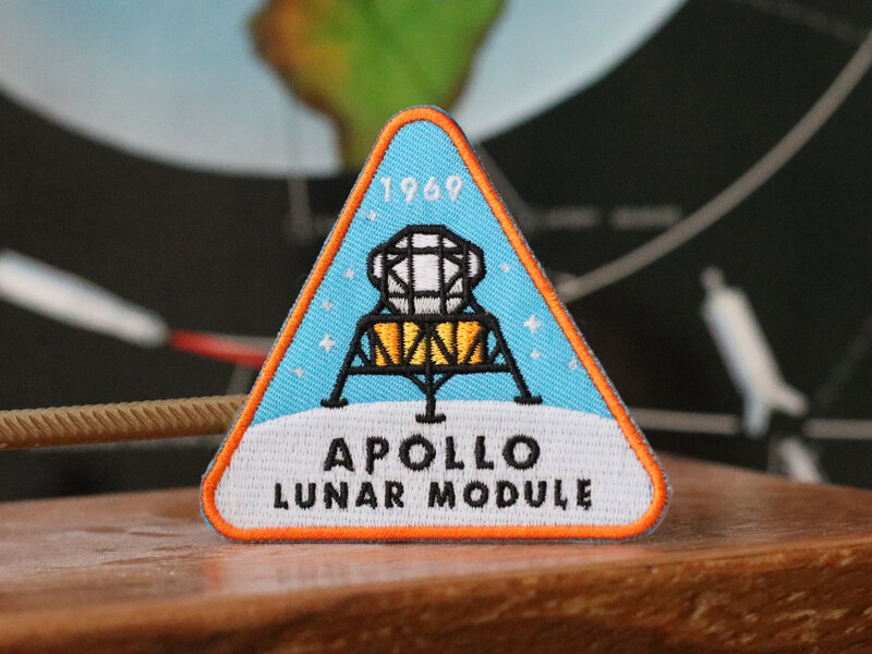 Apollo Lunar Module embroidered patch on a desk in front of a globe