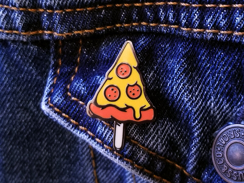 Pepperoni pizza slice on a stick enamel pin on a denim jacket pocket