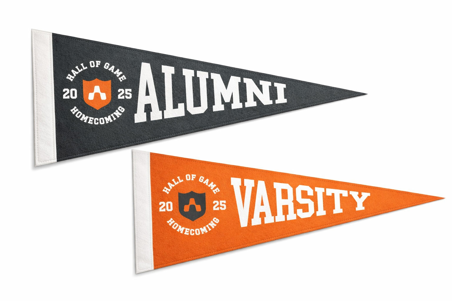 Two felt pennants: a charcoal Alumni pennant and an orange Varsity pennant, each with the Hall of Game Homecoming 2025 roundel