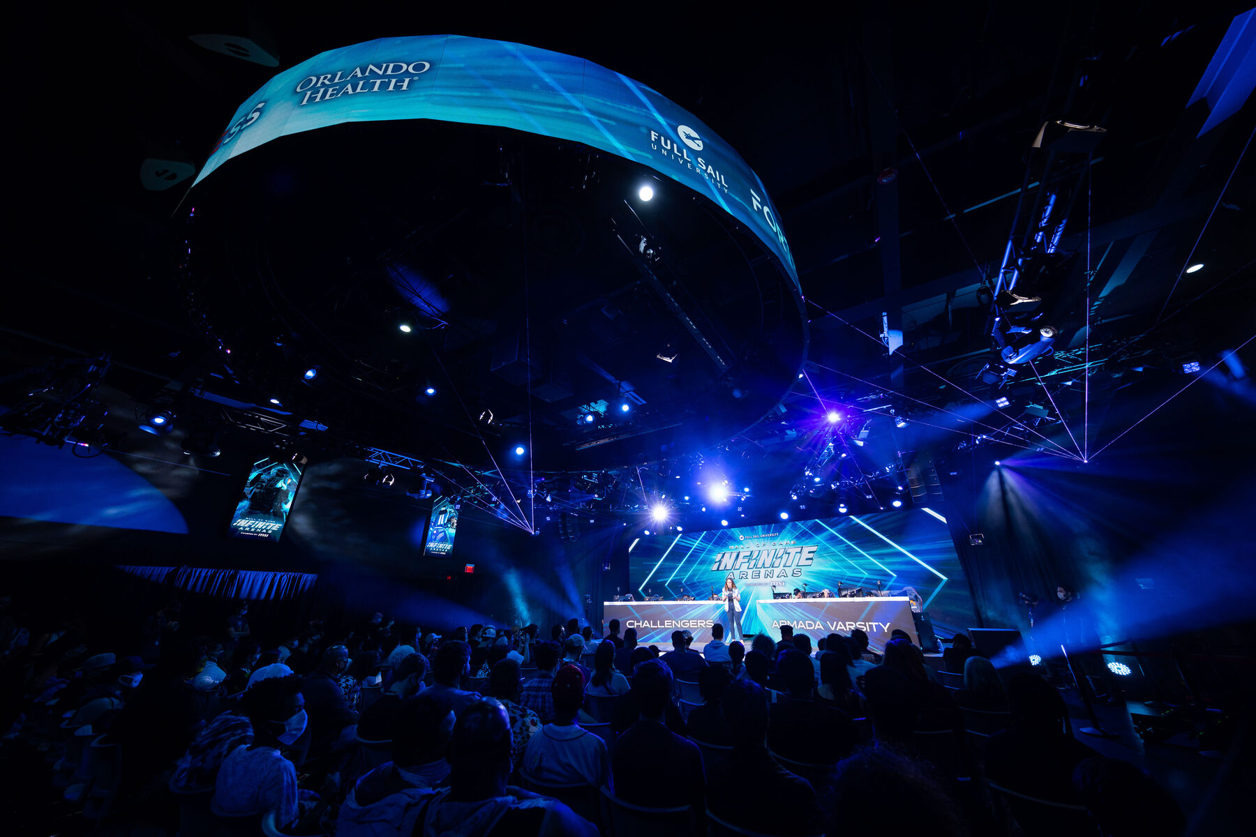 The crowd under the ring, with the stage glowing in the distance