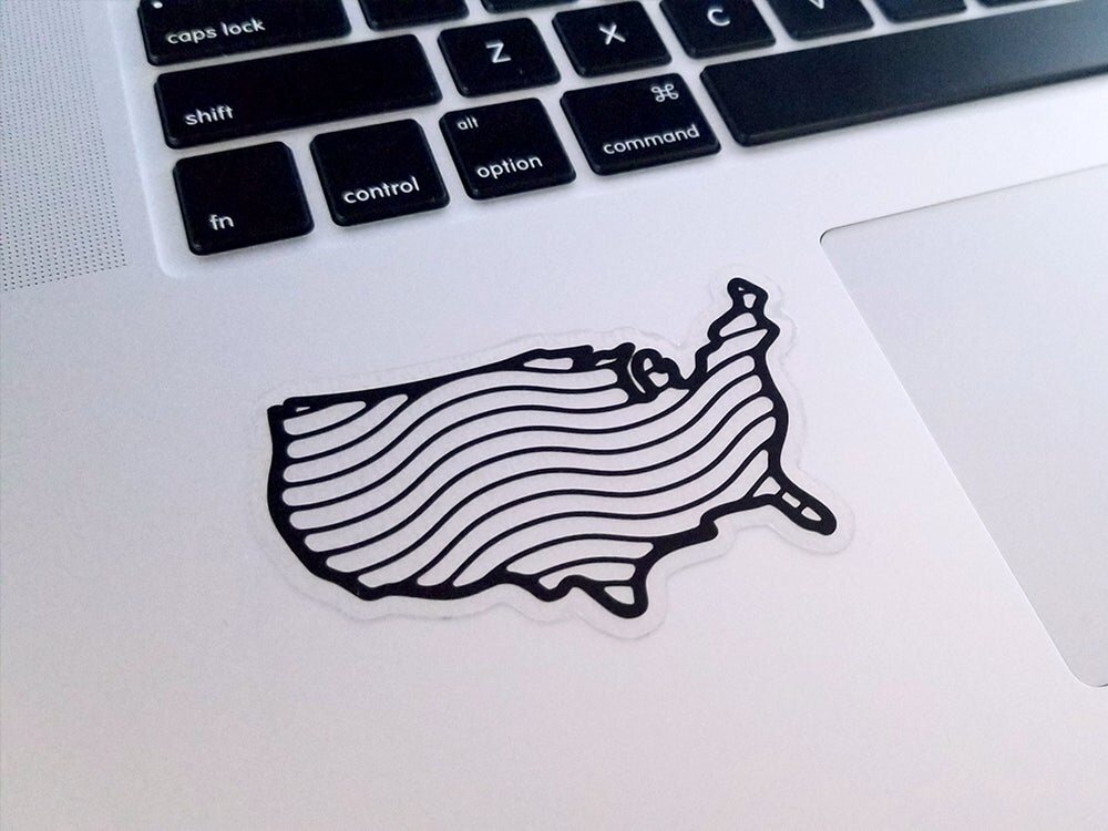 Clear sticker of a line-drawn United States map on a white laptop