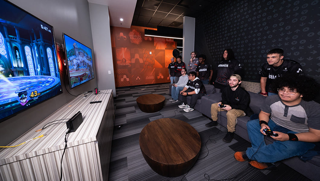 The console room: an orange feature wall with Armada marks, a lounge sofa and large screens